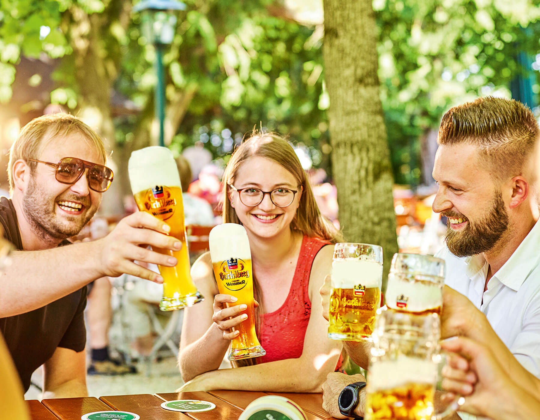 Brauerei Hacklberg Drei Freunde sitzen im Biergarten und trinken ein Hacklberger Bier