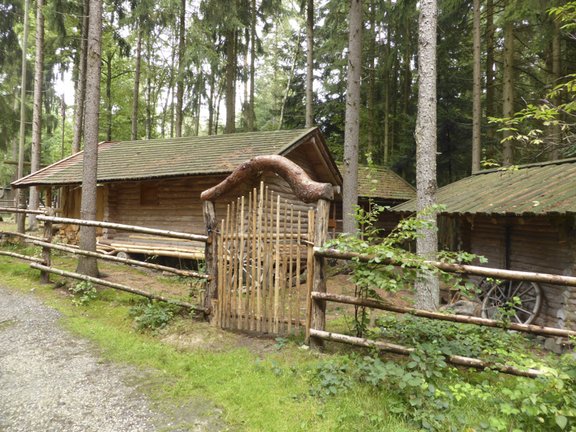Tor aus Holz zu einem Grundstück mit drei Häusern