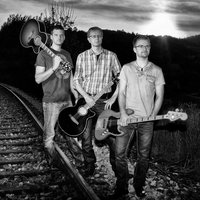 Village Kings Drei Männer mit Gitarren auf Zuggleisen
