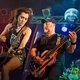 zwei Personen auf einer Bühne spielen Gitarre