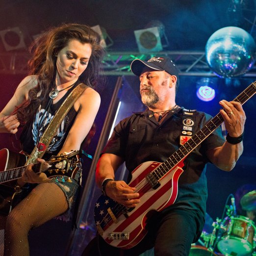 zwei Personen auf einer Bühne spielen Gitarre