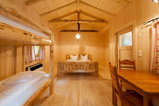 Blockhütten mit authentischem Wild West-Flair Hotelzimmer in einer Blockhütte mit Doppelbett und einem Stockbett