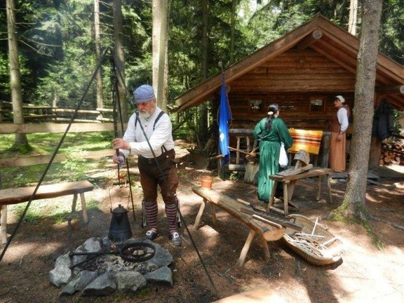 Mann befestigt Kessel über Feuerstelle