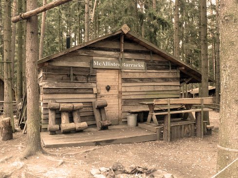Gebäude aus Holzbrettern mit Schild "McAllister Barracks"