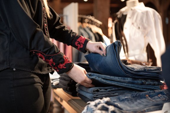 Verkäuferin stöbert durch Jeans