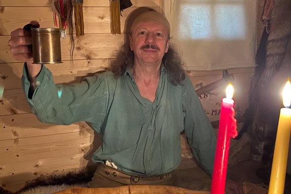 Mann in Waldland Kleidung hebt Krug an