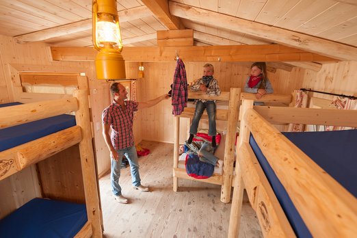 Projekttage im Wilden Westen Drei Kinder sitzen auf Stockbetten, ein Erwachsener steht daneben