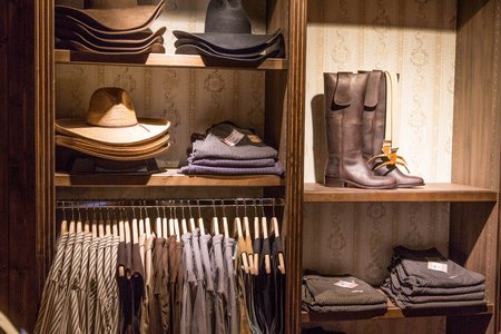 Hüte, Stiefel, Hosen und Hemden in einem Regal