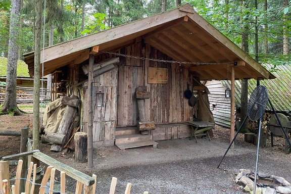 Haus aus Brettern mit Feuerstelle