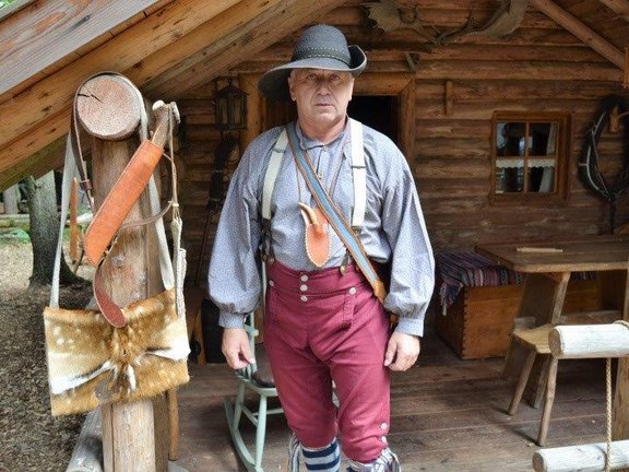 Mann auf der Veranda eines Holzhauses