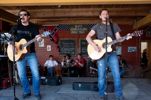 Zwei Männer mit Gitarren singen auf einer Bühne