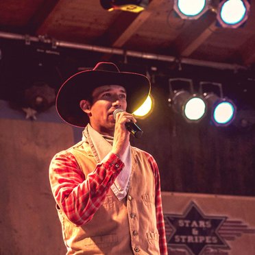 Mann mit Cowboyhut spricht in ein Mikrofon