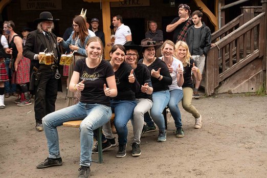 Sechs Frauen sitzen auf einer Bierbank