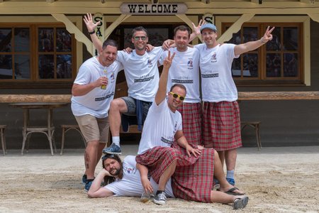 Gruppe aus Männern mit weißen T-shirt und Schottenröcken