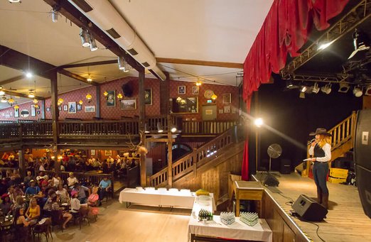 Frau hält Vortrag auf einer Bühne in der Music and Dance Hall
