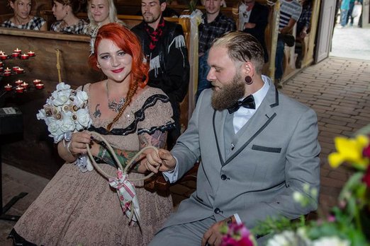Heiraten in authentischer Kulisse Braut und Bräutigam in einer Kirche, halten ein Seil