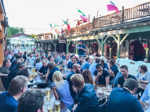 Mann hält Vortrag vor Menschen, die an Biertischen sitzen