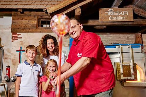 Glasbläser führt einer Familie sein Handwerk vor