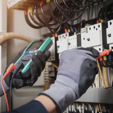 Elektriker/in Person testet ein Gerät auf Strom
