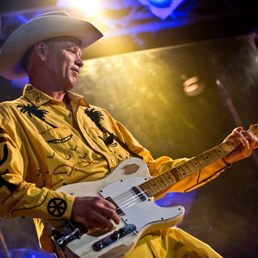 Mann mit Gitarre und Cowboyhut auf der Bühne