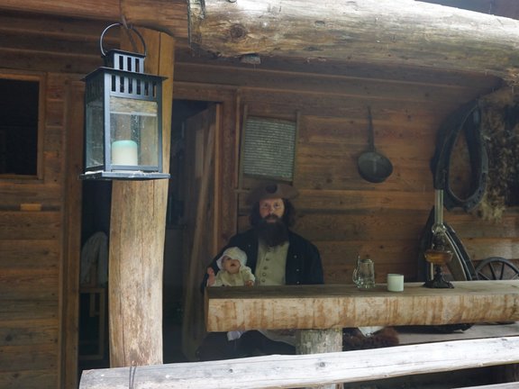 Mann mit Piratenhut sitzt auf Veranda mit Baby auf dem Schoß