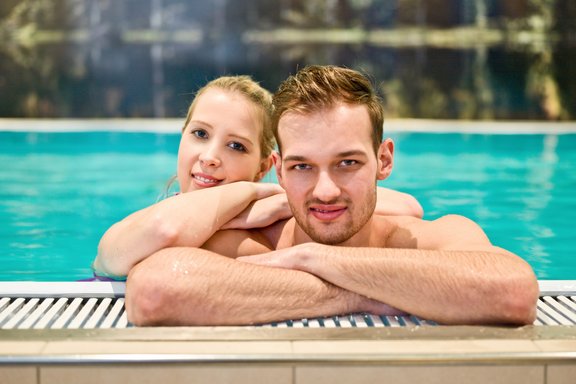 Zwei Personen in einem Hallenbad