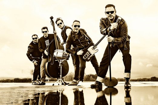 Bandfoto mit fünf Männern und ihren Instrumenten