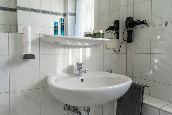 Waschbecken mit Spiegel, Handtuchhalter und Föhn