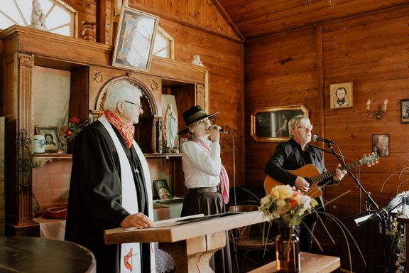Pfarrer und zwei Musiker beim Altar